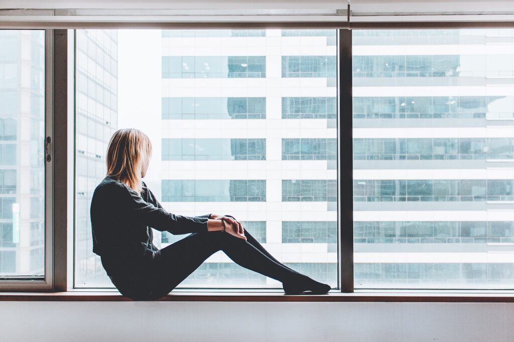 Girl sitting next to a window 