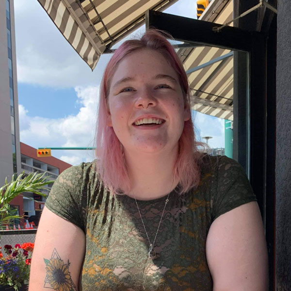 A photo of Alexis Kelly smiling while sitting on a patio outside