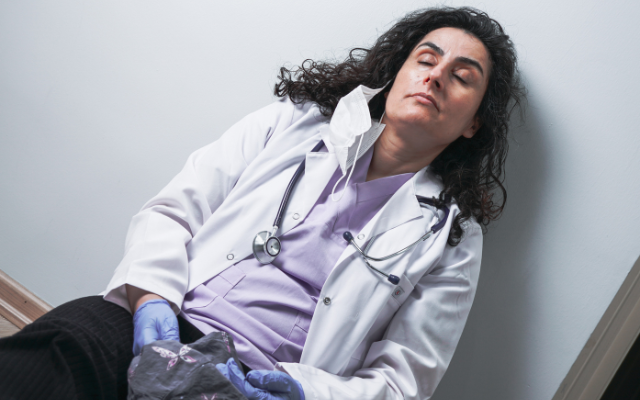 Exhausted doctor sitting on floor